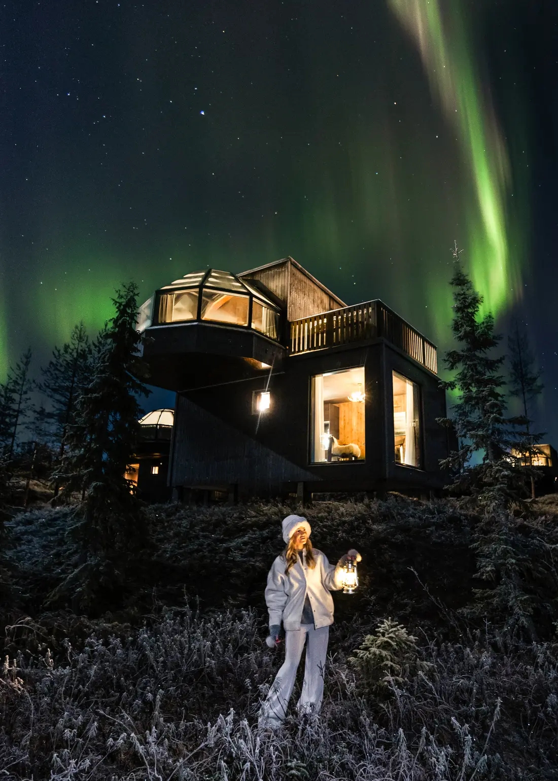 Northern lights above a SkyView glass igloo suite at night