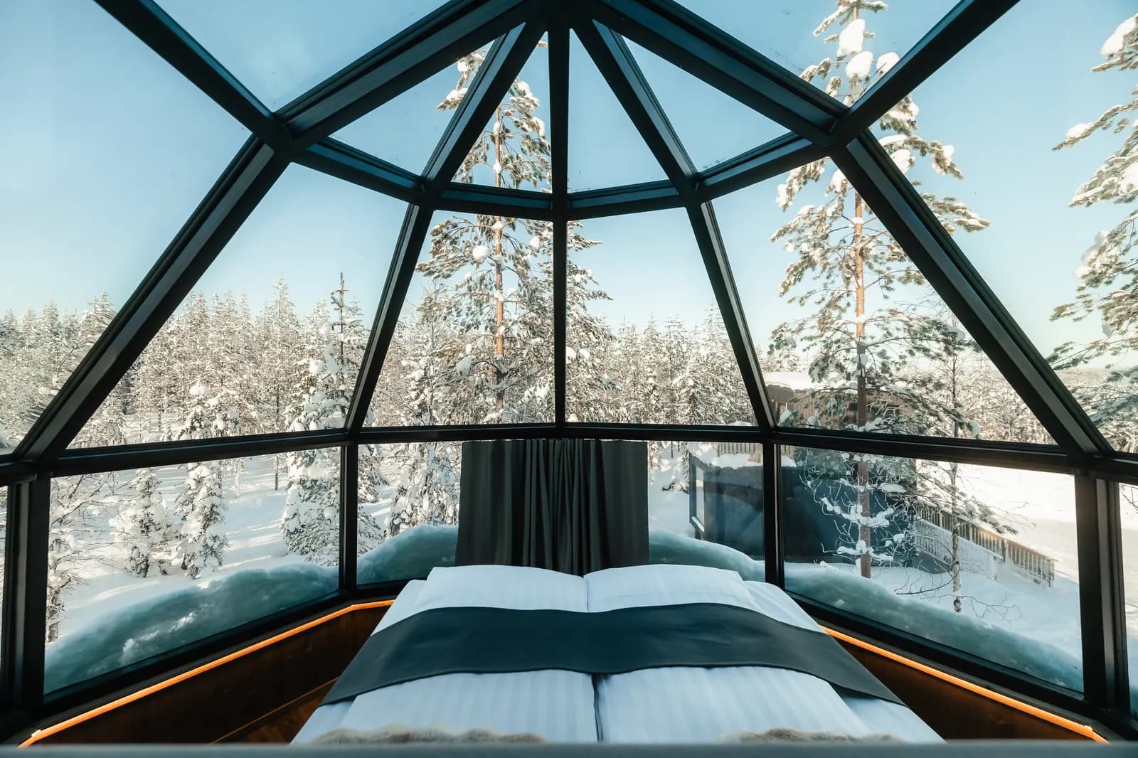 Bed under the 360° glass roof of a SkyView igloo suite