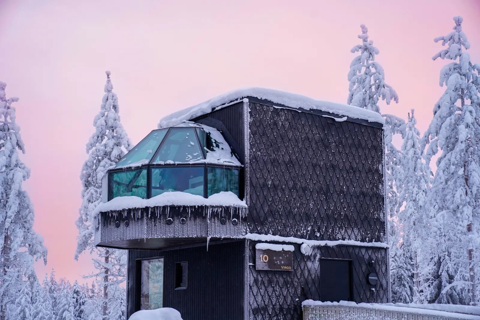 SkyView igloo suite in the snowy forest at dusk